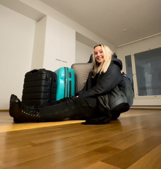QMU student Essi sitting on the floor in front of suitcases