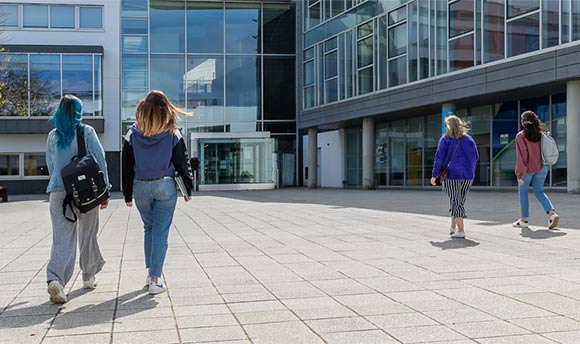 A group of students walking into QMU campus