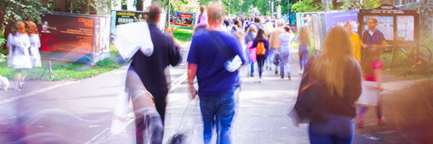 PBlurry image of a busy street, centred is a couple walking a dog, Edinburgh