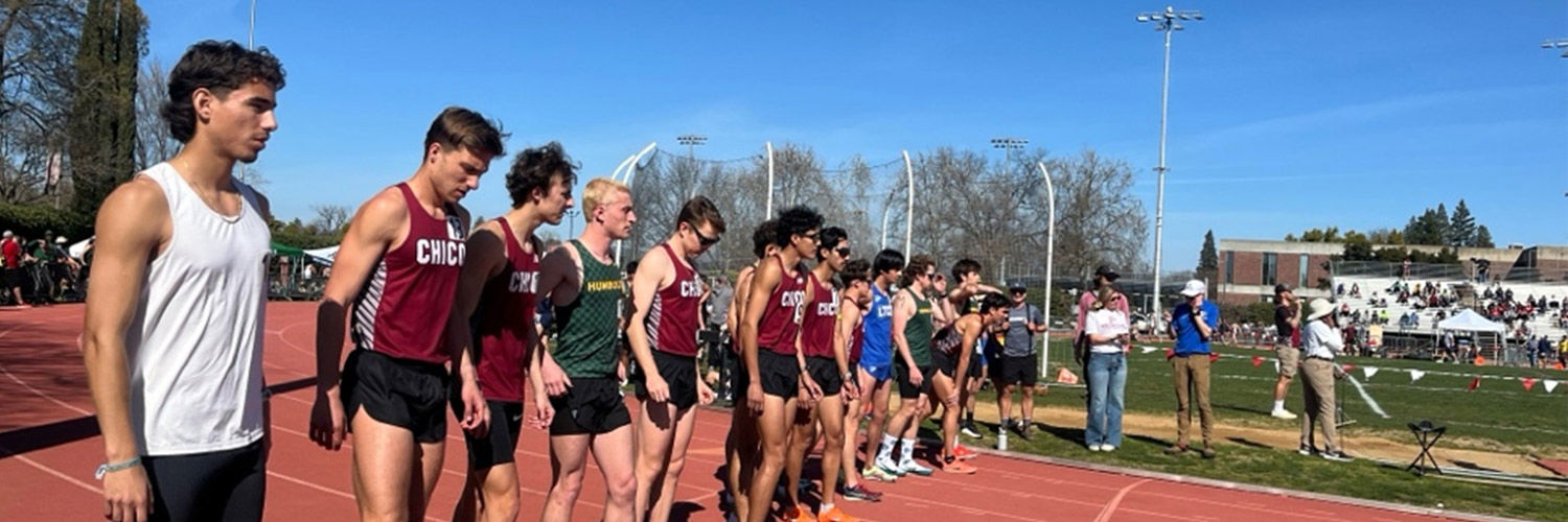 A row of runners lined up at the start of a racetrack