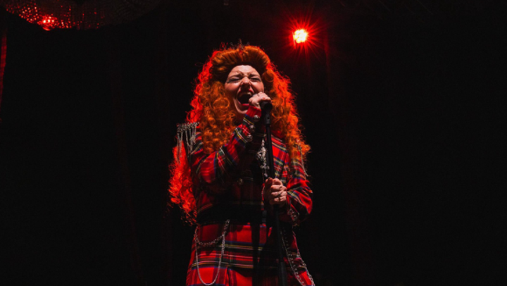 Promotional image for Mary, Queen of Rock (Mary singing into a mic)