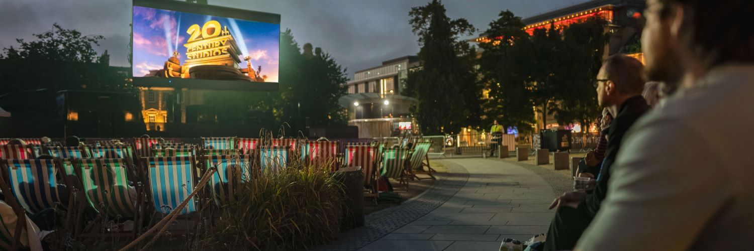An outdoor cinema scene with lawn chairs and the 20th century fox logo.