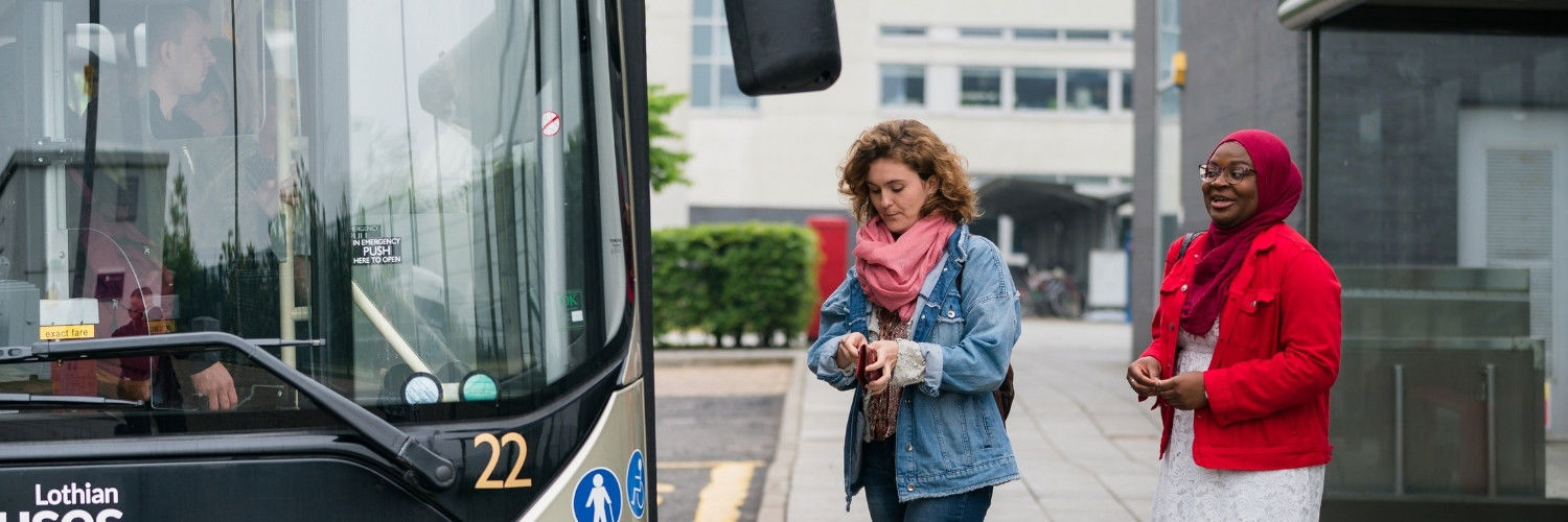 Two female students boarding a Lothian bus at the QMU campus bus stop