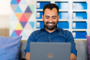 Image of staff member smiling at computer