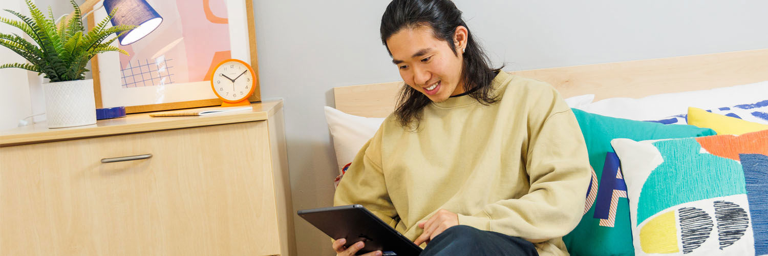A student using a tablet device in their QMU Student Accommodation