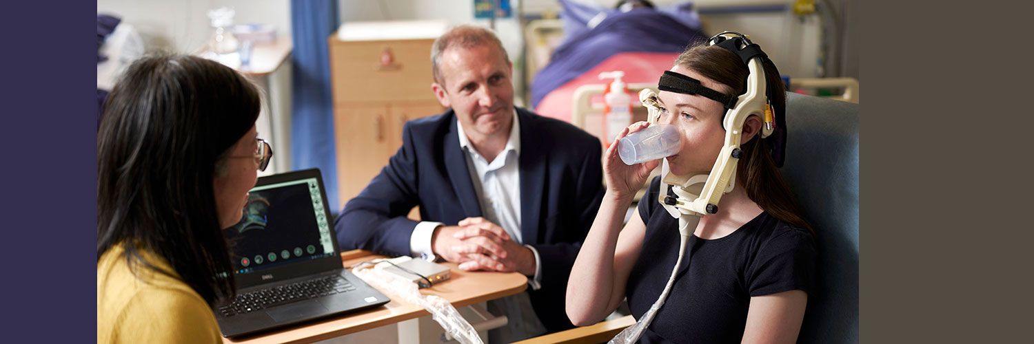 Speech and Language lecturer demonstrates use of ultrasound technology on a patient with swallow issues to Michael Matheson, Cabinet Secretary for the Scottish Government. Ultrasound probe is positioned under patients throat to view swallow movement on a computer screen.