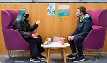 A Queen Margaret University student giving chatting with another student