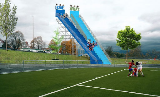 The corner of a football pitch with two very tall 'home' and 'away' spectator stands.