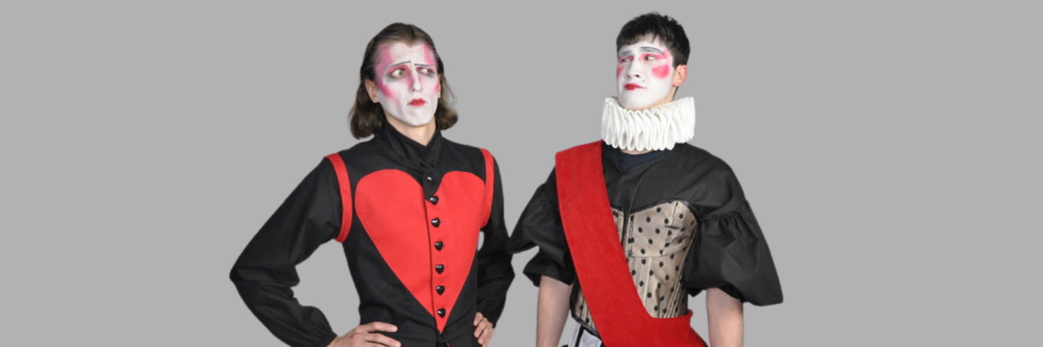 Two men dressed in red and black theatrical costumes with white painted faces and make up.