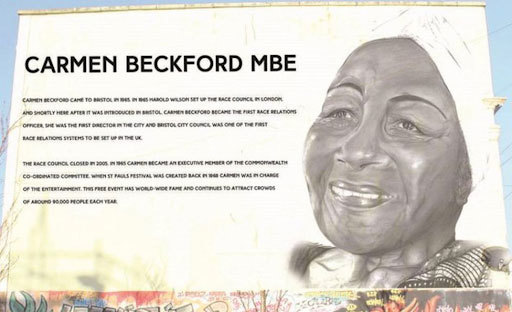 A close up of a wall inscribed with information about Carmen Beckford MBE