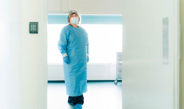 Medical staff wearing PPE in a doorway