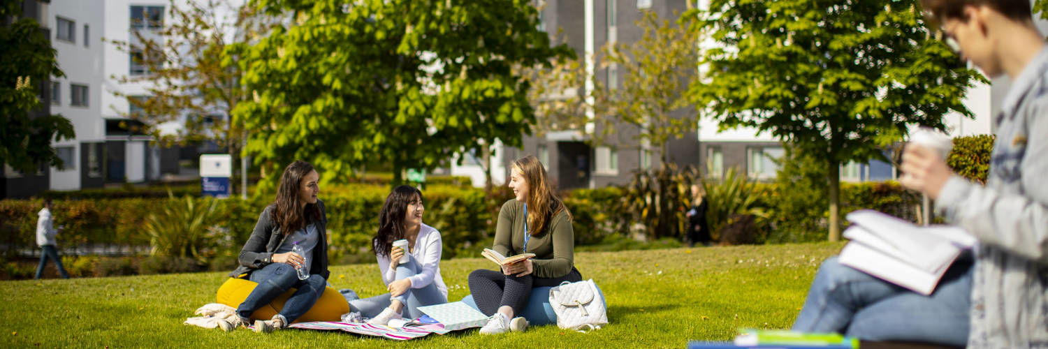 Students relaxing on the grass outside Queen Margaret University Campus, Edinburgh