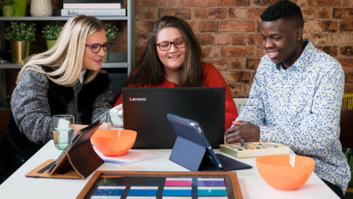 A group of students working away at a laptop