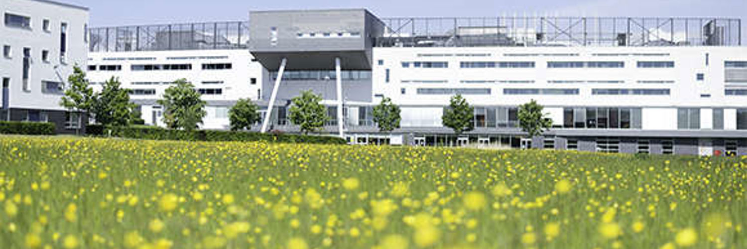 A low angle image of Queen Margaret University Campus with flowers in the foreground