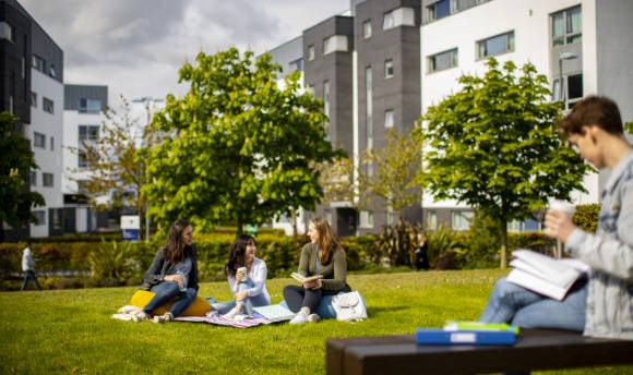 Students relaxing on the grass outside Queen Margaret University Campus, Edinburgh