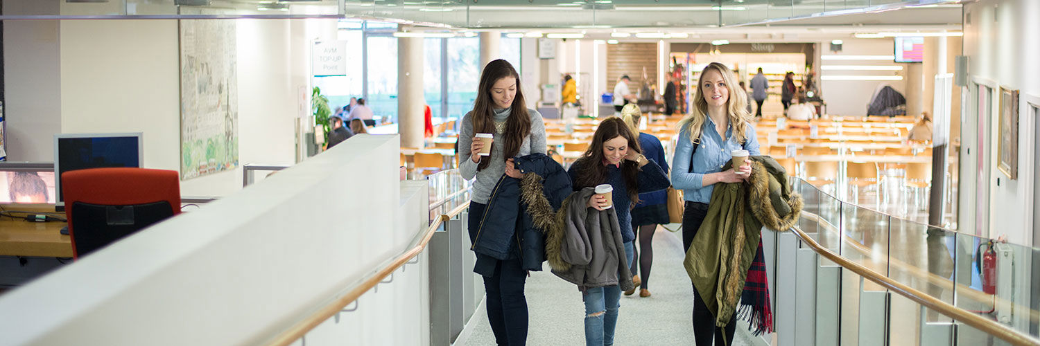 3 girls walking up an access ramp with drinks in their hands, QMU, Edinburgh