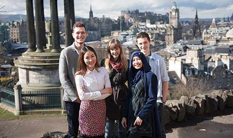 Group of students smiling in front of the Dugald Stewart Monument, Edinburgh
