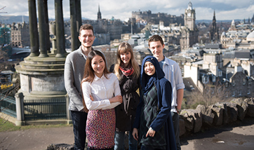 Group of students smiling in front of the Dugald Stewart Monument, Edinburgh