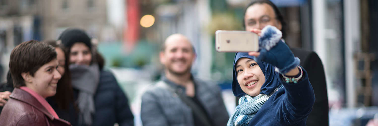 A group of friends pose whilst another snaps a photograph, Edinburgh City Centre