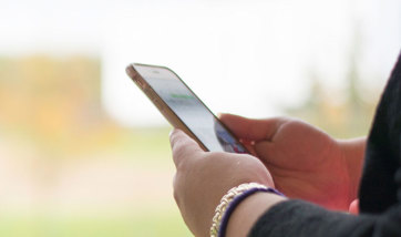 Wide angle view of a person's hands holding their mobile phone