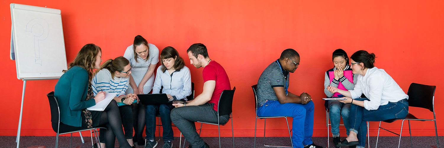 Two groups of QMU students sat in circles working on a group exercise together