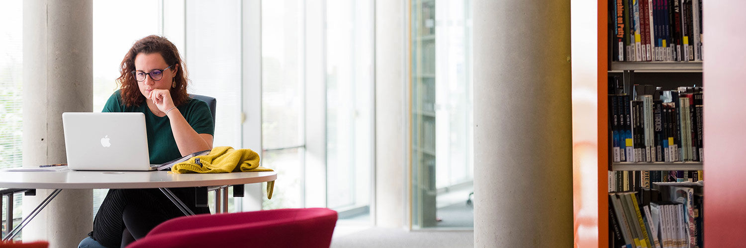 A young woman working intently on a Macbook laptop, QMU, Edinburgh