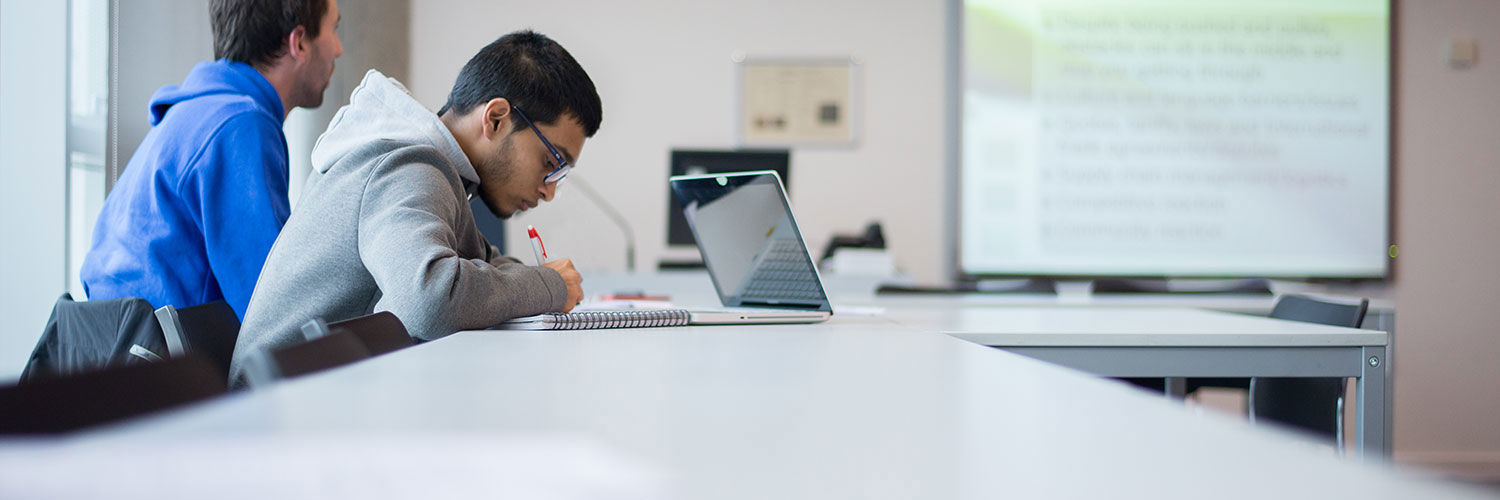 A Queen Margaret University student taking notes during a class, Edinburgh