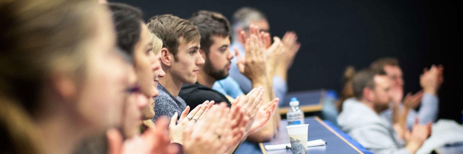 Row of students in QMU lecture hall applauding the speaker, Edinburgh