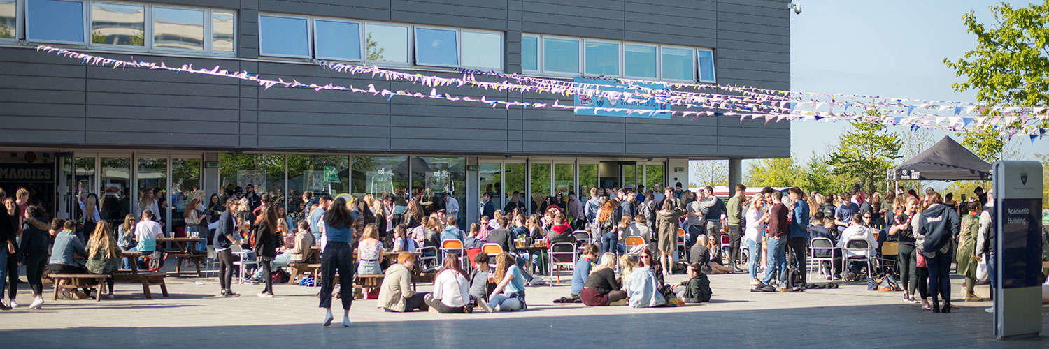 Outdoor seating at the Student Union overflowing with students