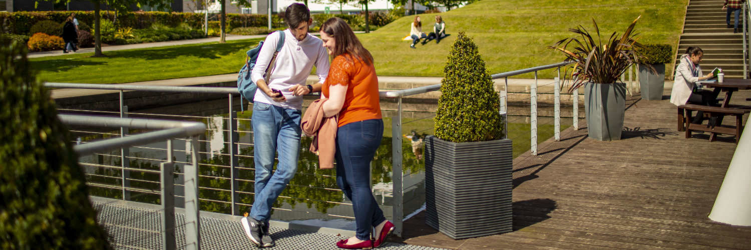 A couple of students chatting in the sun at Queen Margaret University, Edinburgh