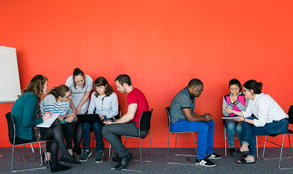 Two groups of QMU students sat in circles working on a group exercise together