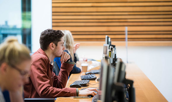 Row of Queen Margaret University students working on desktop computers