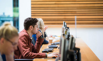 Row of Queen Margaret University students working on desktop computers