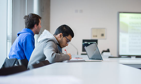 A Queen Margaret University student taking notes during a class, Edinburgh