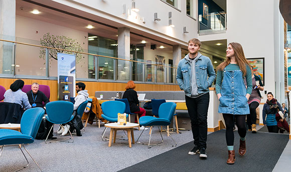 Two Queen Margaret University students walking through the main atrium