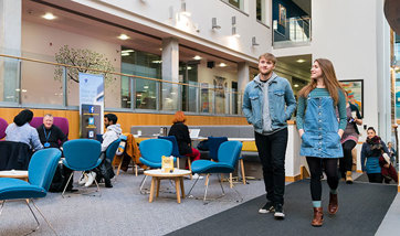 Two Queen Margaret University students walking through the main atrium