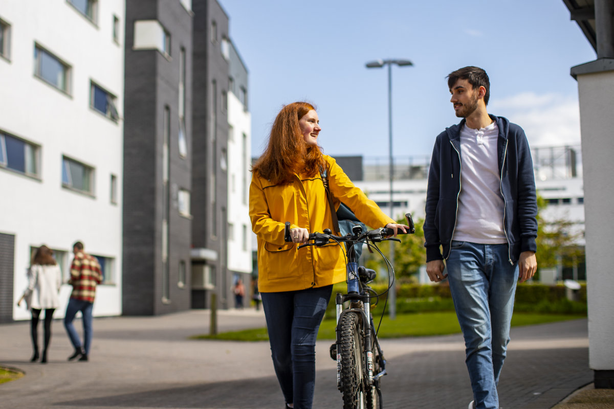 Two students walking in the sunshine and talking