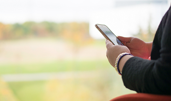 Wide angle view of a person's hands holding their mobile phone