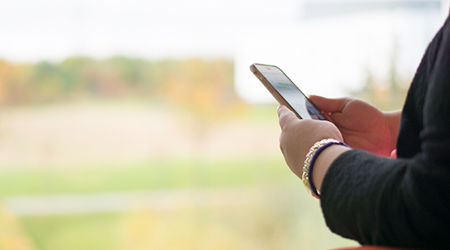 Wide angle view of a person's hands holding their mobile phone
