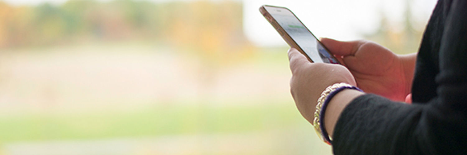 Wide angle view of a person's hands holding their mobile phone