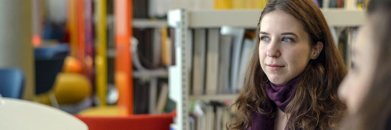 Queen Margaret University student in the library, looking into the distance