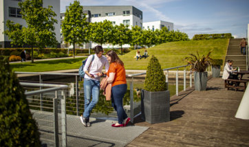 A couple of students chatting in the sun at Queen Margaret University, Edinburgh