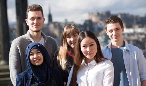 Group of students smiling in front of the Dugald Stewart Monument, Edinburgh