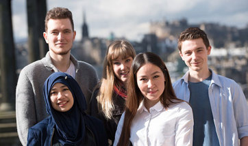 Group of students smiling in front of the Dugald Stewart Monument, Edinburgh