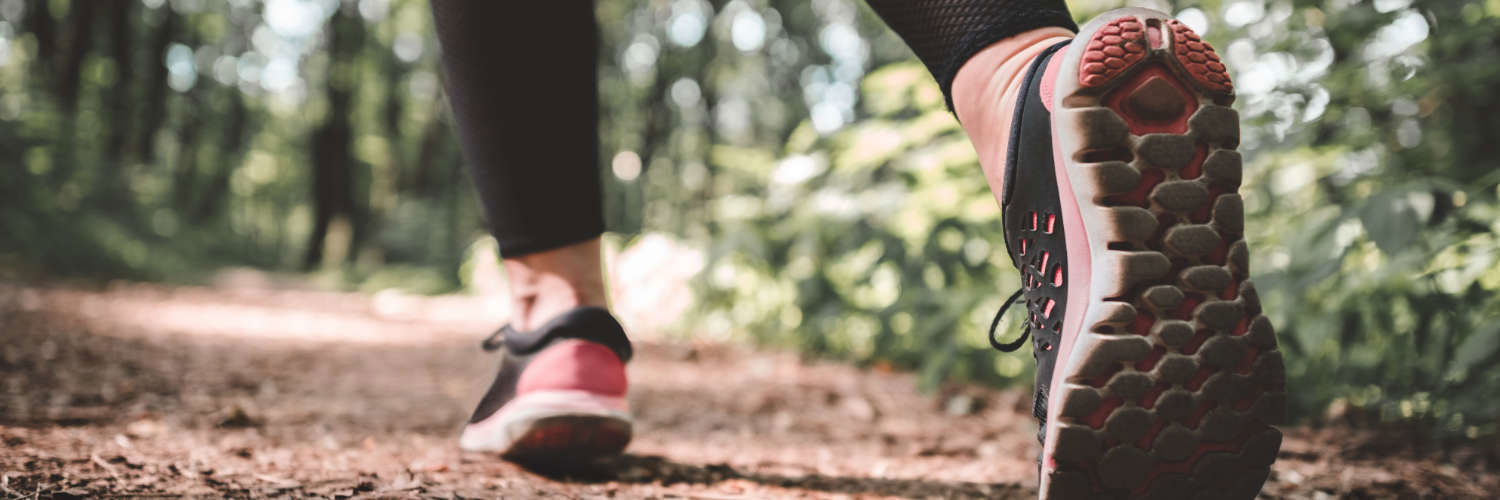 A woman walking on a woodland trail
