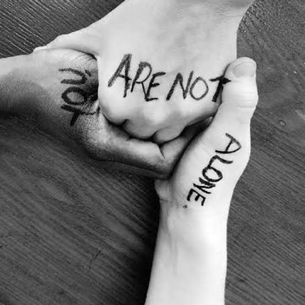 Three hands held together, the words on each line up to read "You are not alone".