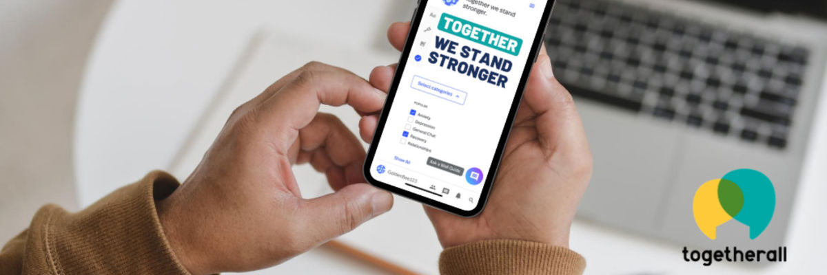 A pair of hands holding a phone and using togetherall