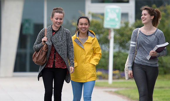 Three happy students on Queen Margaret University campus