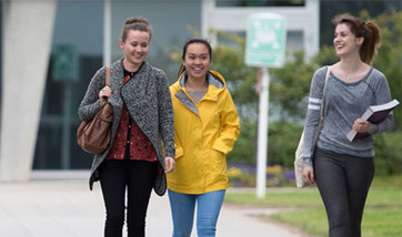 Three happy students on Queen Margaret University campus