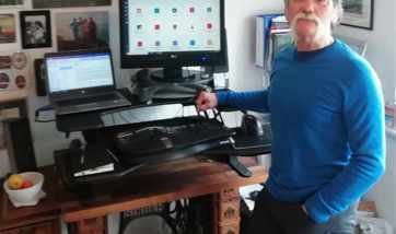 Barry Dickson standing next to an ergonomic workstation